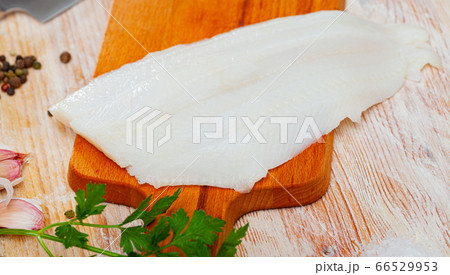 Fillet of raw halibut fish before cooking on wooden background Fillet of raw halibut fish before cooking on wooden background 66529953