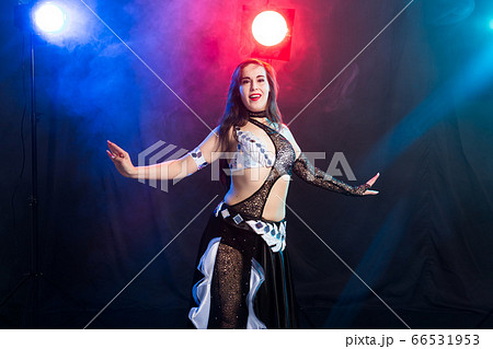 Young woman dancing in Tribal Fusion style. Belly dance on the stage. Young woman dancing in Tribal Fusion style. Belly dance on the stage. 66531953