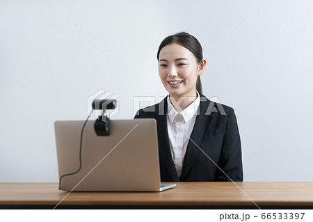 オンライン面接イメージ　ウェブカメラに向かって話すスーツ姿の若い女性 66533397