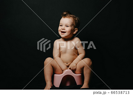 happy baby boy sitting on a potty and laughing 66538713