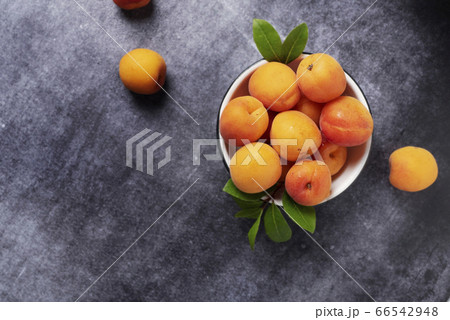 Sweet fresh apricots in the white bowl Sweet fresh apricots in the white bowl 66542948