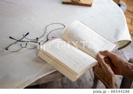 老眼鏡をもって読書しようとしている高齢女性 老眼鏡をもって読書しようとしている高齢女性 66544286