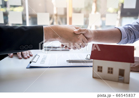 Real estate agent are shaking hands after good Real estate agent are shaking hands after good 66545837