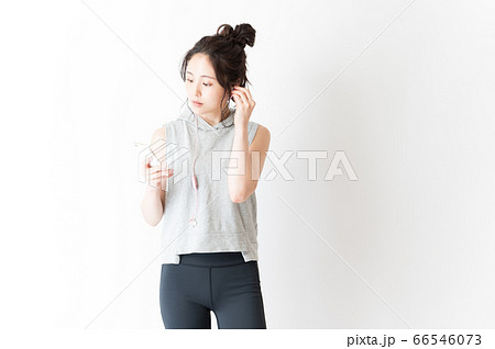 音楽を聴くスポーツウェアの女性 66546073