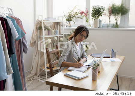 Caucasian female designer work on laptop making notes Caucasian female designer work on laptop making notes 66548313