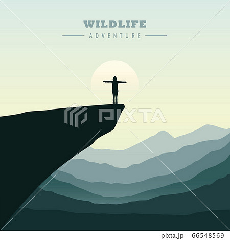 hiking adventure girl on a cliff in at sunrise with mountain view 66548569