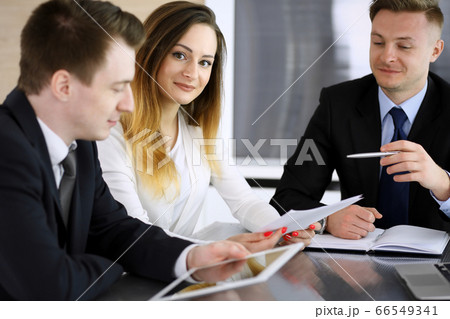 Business people or lawyers discussing questions at meeting in modern office. Unknown businessman and woman with colleague sitting and working at the glass desk. Teamwork and partnership concept 66549341
