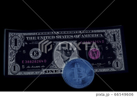 Bitcoin coin on one U.S. dollar banknote on black 66549606