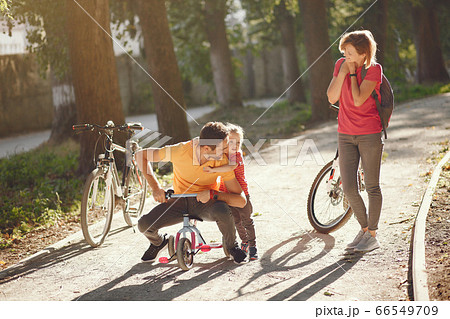 Family with a bicycle in a summer park Family with a bicycle in a summer park 66549709