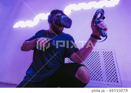 The guy is sitting in virtual reality. Neon retro style. The photo shows the effect of grain, noise. 66550079