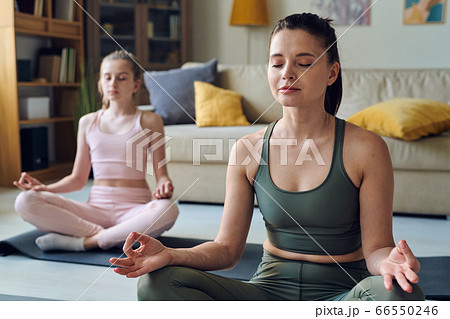 Meditating with daughter at home 66550246