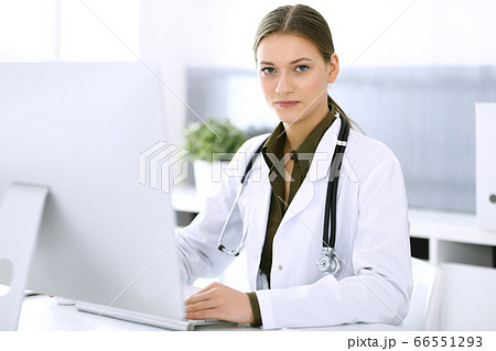 Doctor typing on pc computer while sitting at the desk in hospital office. Physician woman at work. Data in medicine and healthcare 66551293