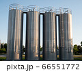 Four stainless steel silos shot in the morning sun with a clear blue sky 66551772