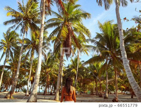 Woman alone at paradise with white beach, turquoise water and palm trees in Balabac in Philippines	 66551779