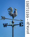 Weather vane showing direction of wind against clear blue sky, vertical 66551865