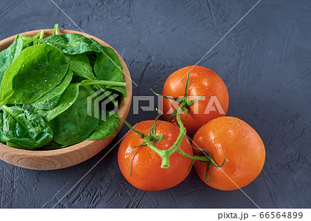 Fresh spinach leaves in wooden bowl and tomato on 66564899