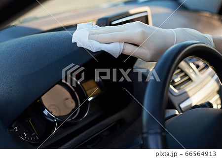 Woman cleaning car dashboard with a disinfection Woman cleaning car dashboard with a disinfection 66564913