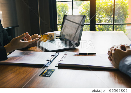 The bank clerk is talking to a customer who The bank clerk is talking to a customer who 66565302