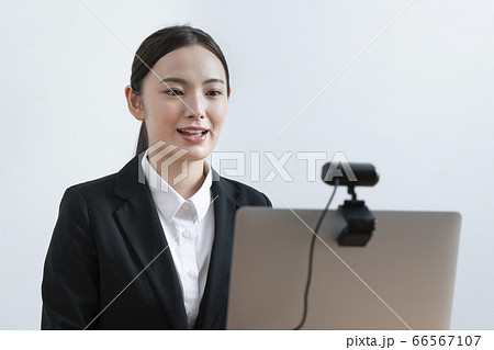 オンライン面接　ウェブ就活　イメージ　ウェブカメラに向かって話す若い女性　 66567107