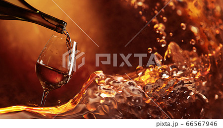 Wine being pouring into a glass. Wine being pouring into a glass. 66567946