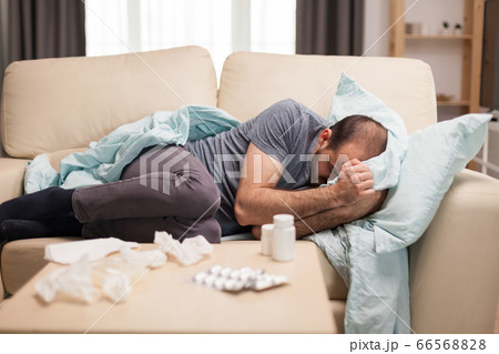 Sick man lying on sofa 66568828