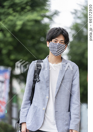 チェッカー柄のマスクを着用した若い男性 66572930