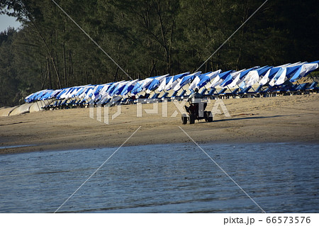 バングラデシュのコックスバザールビーチ　砂浜を走るバギーと砂浜に並ぶビーチパラソル 66573576