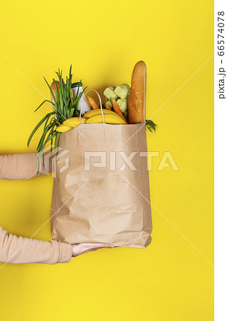 Girl or woman holds a paper bag filled with food ingridients 66574078