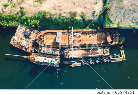 Aerial view of old rusty boats and ships on the sea at sunset in summer. Indusrtial landscape  66574851