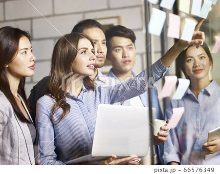 team of asian and caucasian entrepreneurs working together on business plans 66576349
