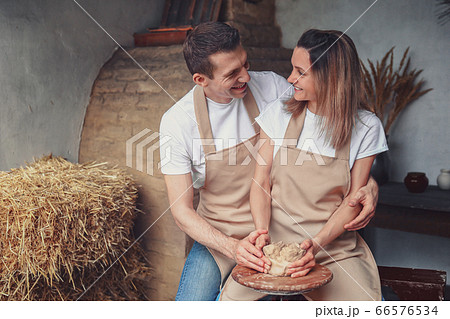 romantic couple in love working together on potter wheel and sculpting clay pot man and a young woman mold a vase in craft studio workshop romantic couple in love working together on potter wheel and sculpting clay pot man and a young woman mold a vase in craft studio workshop 66576534