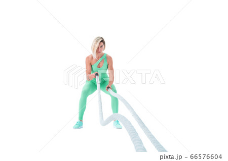 Woman doing exercises with battle rope. Woman doing exercises with battle rope. 66576604
