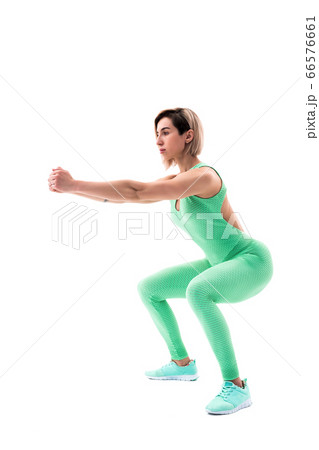 Studio shot of an athletic woman doing squats isolated over white background 66576661
