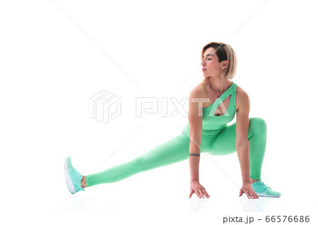 full body portrait of young sporty woman stretching before exercise isolated on white background 66576686