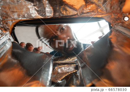 African-american man looking for job in unusual places at his home African-american man looking for job in unusual places at his home 66578030