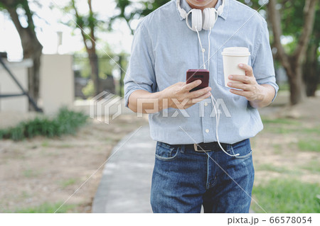 Businessman use smartphone and hold cup coffee in Businessman use smartphone and hold cup coffee in 66578054