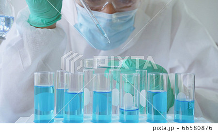 Asian Scientist working on blue test tube to 66580876