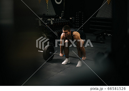 Muscular fit man with perfect beautiful body wearing sportswear lifting heavy barbell from floor Muscular fit man with perfect beautiful body wearing sportswear lifting heavy barbell from floor 66581526