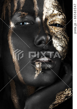 fashion portrait of a dark-skinned girl with gold make-up. Beauty face. fashion portrait of a dark-skinned girl with gold make-up. Beauty face. 66583547