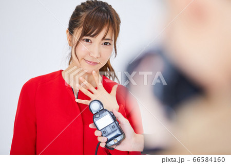 赤いコートを着た若い女性モデルとカメラマン 66584160