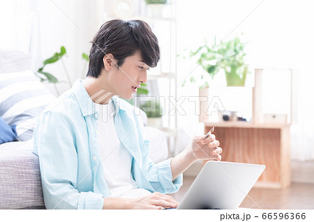 パソコンを見ながらオンラインショッピング楽しむ若い男性 66596366