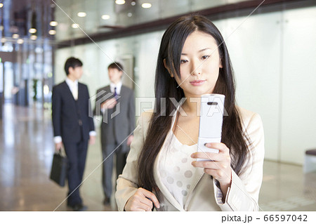 携帯メールを見るOL 66597042