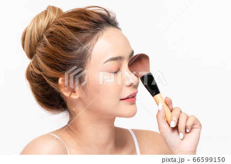 Beautiful Asian young woman smile and holding make up brush with healthy Clean and Fresh skin Beautiful Asian young woman smile and holding make up brush with healthy Clean and Fresh skin 66599150
