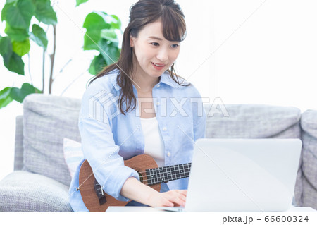 オンラインで楽器(ウクレレ)のレッスンを受ける若い女性 オンラインで楽器(ウクレレ)のレッスンを受ける若い女性 66600324