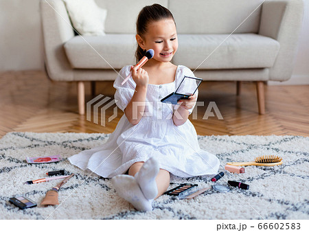 Adorable Asian Girl Making Makeup Playing Sitting On Floor Indoors Adorable Asian Girl Making Makeup Playing Sitting On Floor Indoors 66602583
