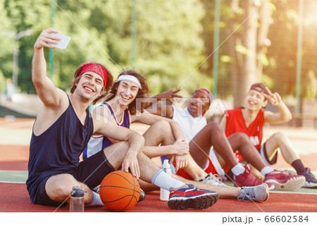 Group of basketball players taking selfie together after training at outdoor arena, copy space Group of basketball players taking selfie together after training at outdoor arena, copy space 66602584