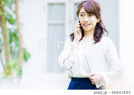 屋外で電話をかける若い女性 66602693