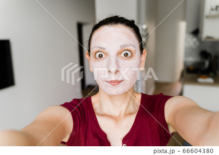 Caucasian woman with face mask live streaming as a beauty blogger 66604380