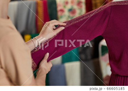 female hand adjusts dress on the mannequin. female hand adjusts dress on the mannequin. 66605185