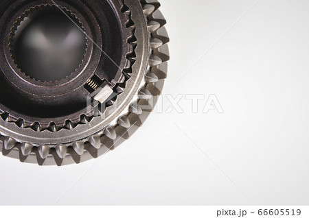 Close-up new shiny metal gear of the switch box is fronted by a gray gradient background. The concept of new spare parts for car maintenance and repair 66605519